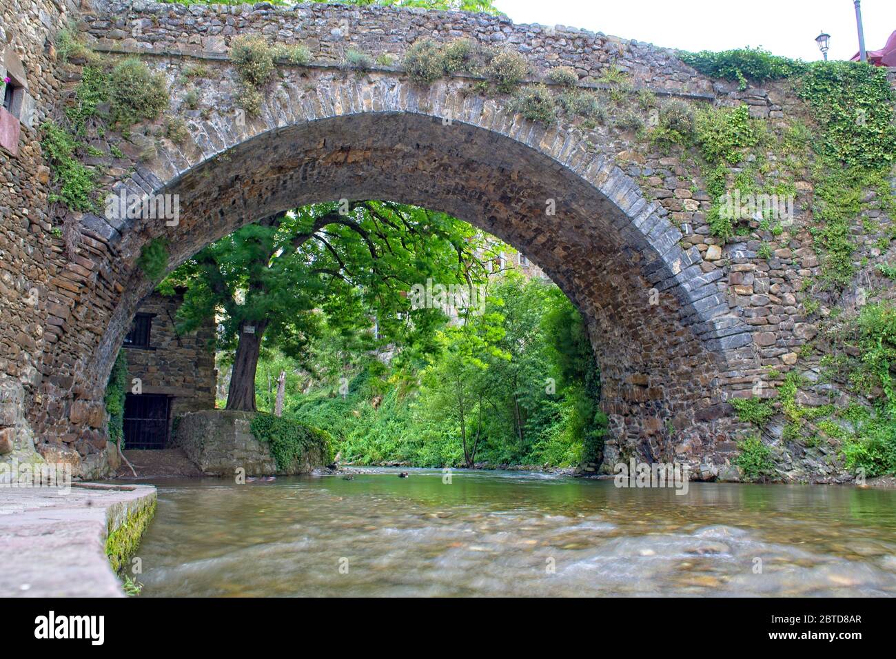 La rivière Quiviesa coule sous un ancien pont en pierre à Potes, Cantabrie, Espagne. Banque D'Images