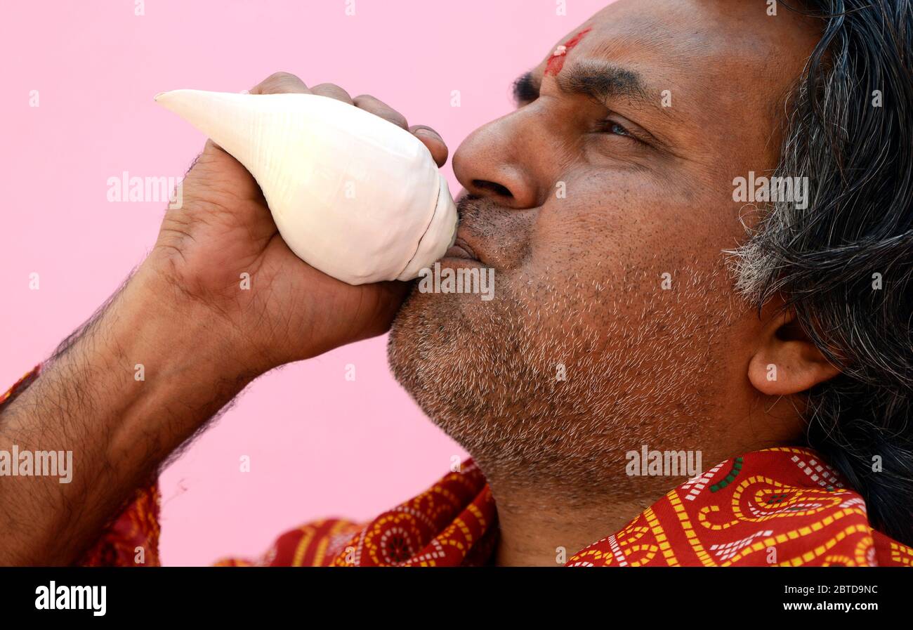 Hindu Priest soufflant la coquille de conch Banque D'Images