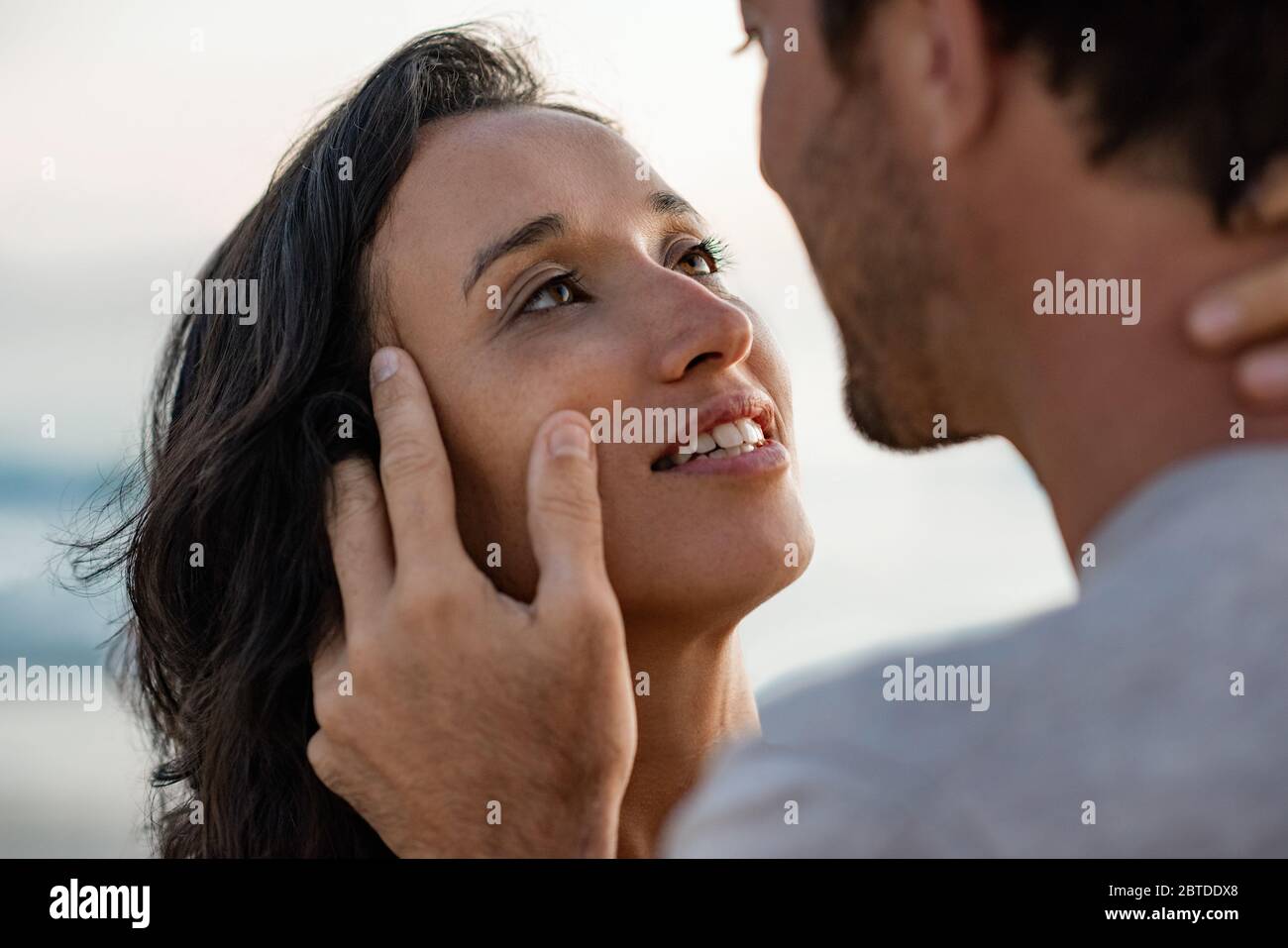 Femme aimante regardant dans les yeux de son mari à la plage Banque D'Images