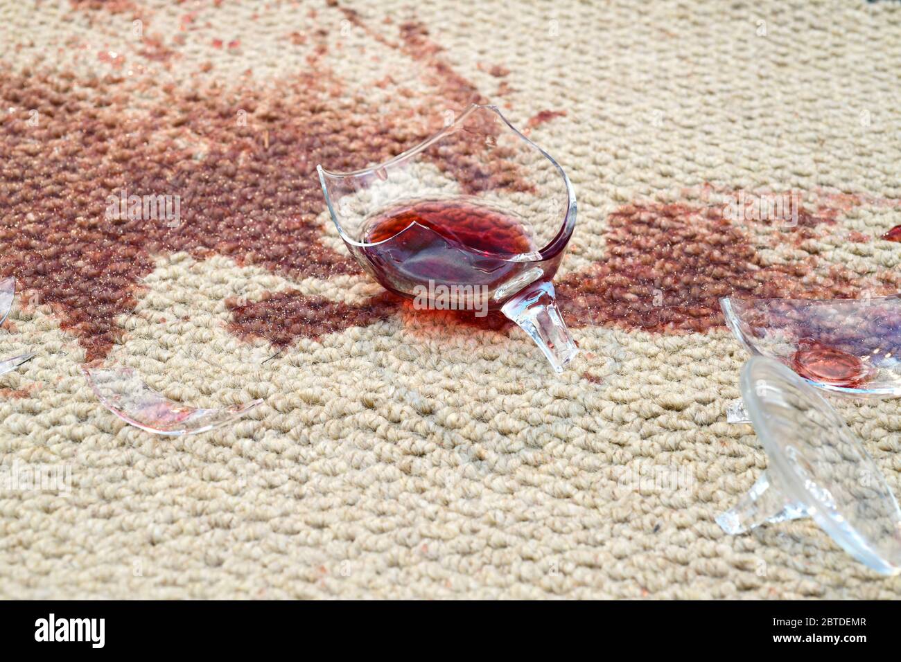 un verre de vin rouge cassé est tombé sur la moquette Banque D'Images