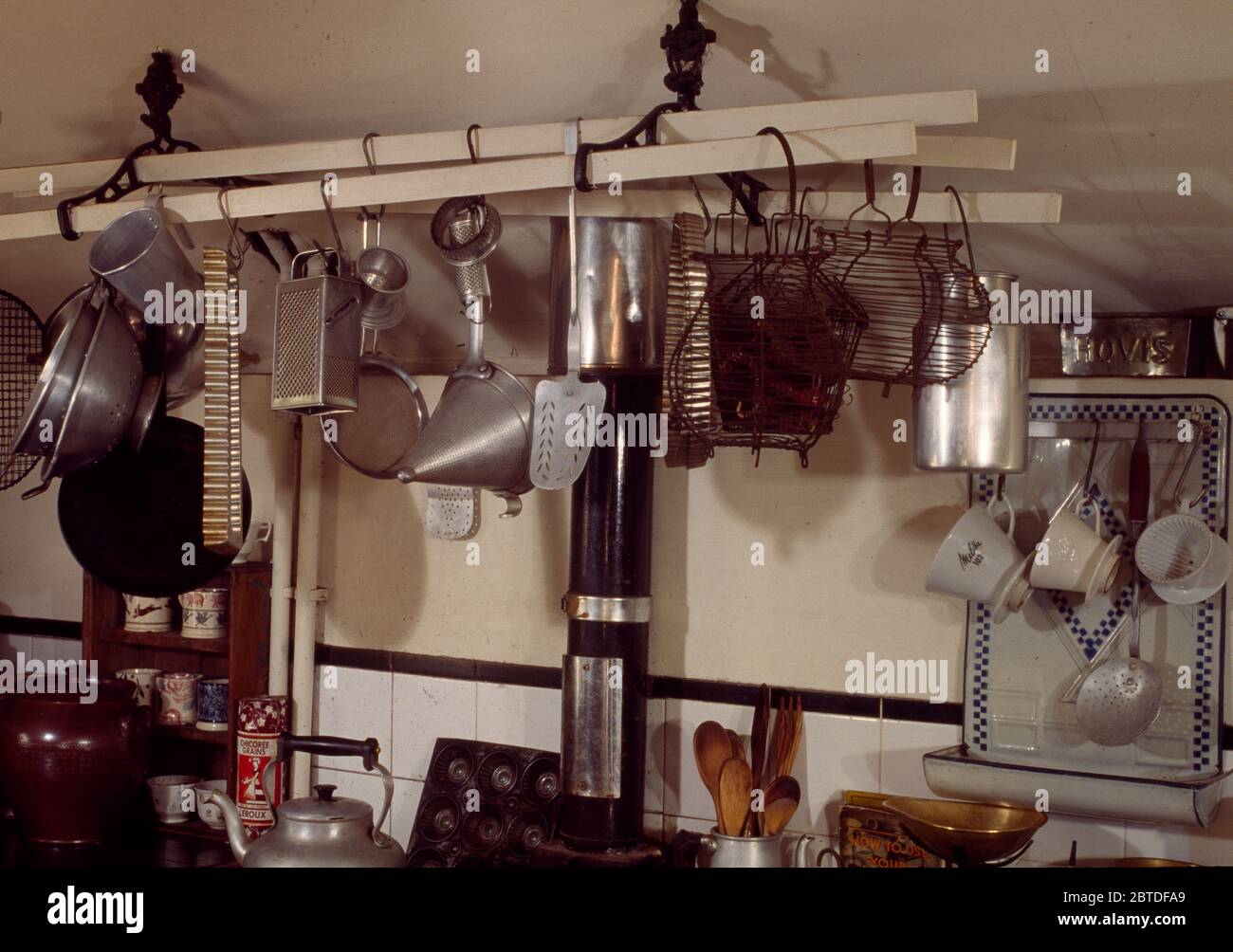 Casseroles et ustensiles en acier inoxydable sur le porte-plafond dans la  cuisine Photo Stock - Alamy