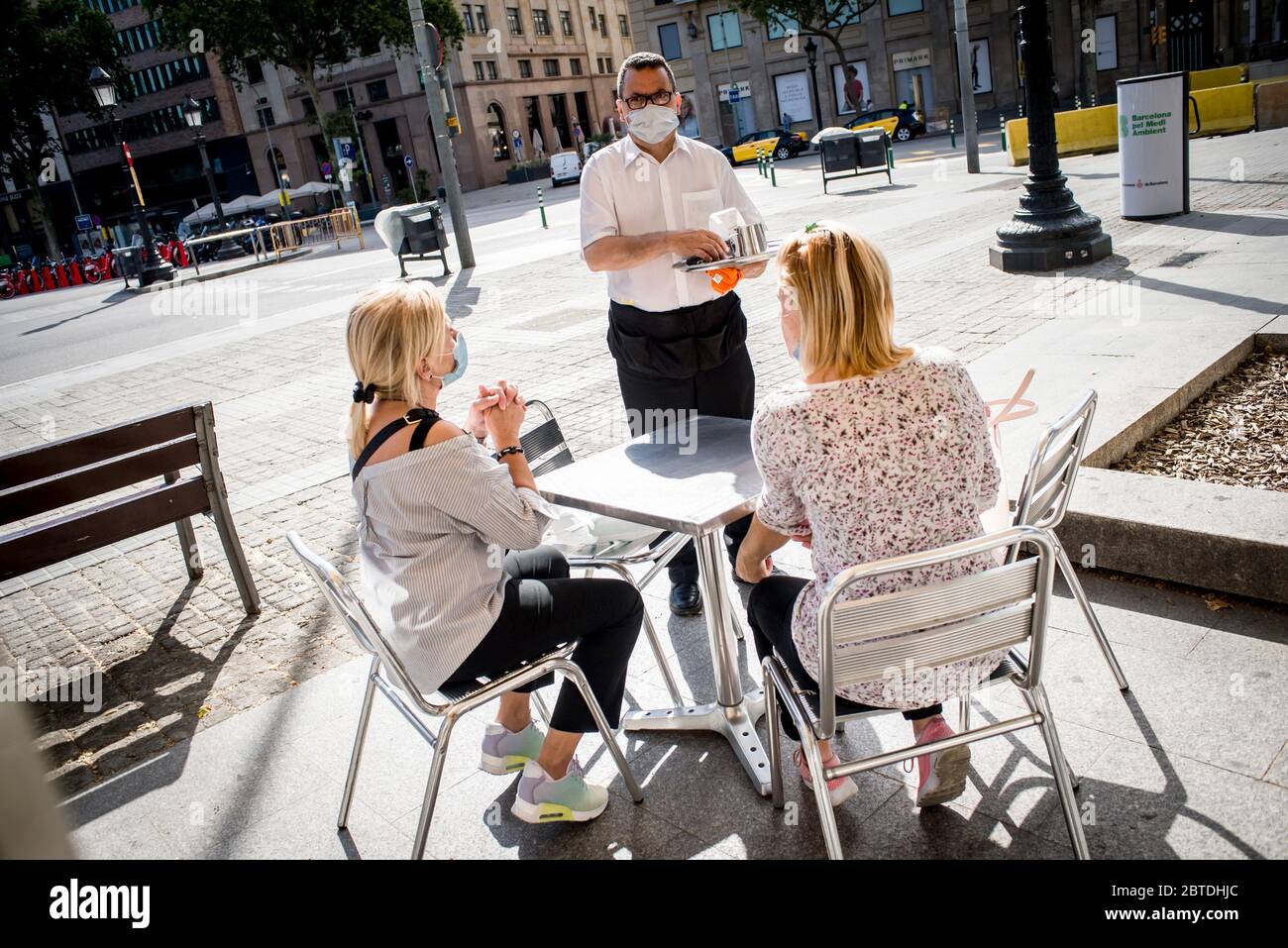 Barcelone, Espagne. 25 mai 2020. 25 mai 2020, Barcelone, Catalogne, Espagne: Un serveur portant un masque de visage assiste les clients sur la terrasse d'un bar de Barcelone. Barcelone et sa zone métropolitaine entrent dans la phase 1 du processus de désescalade du blocage du coronavirus à partir de ce lundi, les terrasses de bars et de restaurants peuvent ouvrir à la moitié de leur capacité après 2 mois de fermeture. Credit:Jordi Boixareu/Alamy Live News Banque D'Images