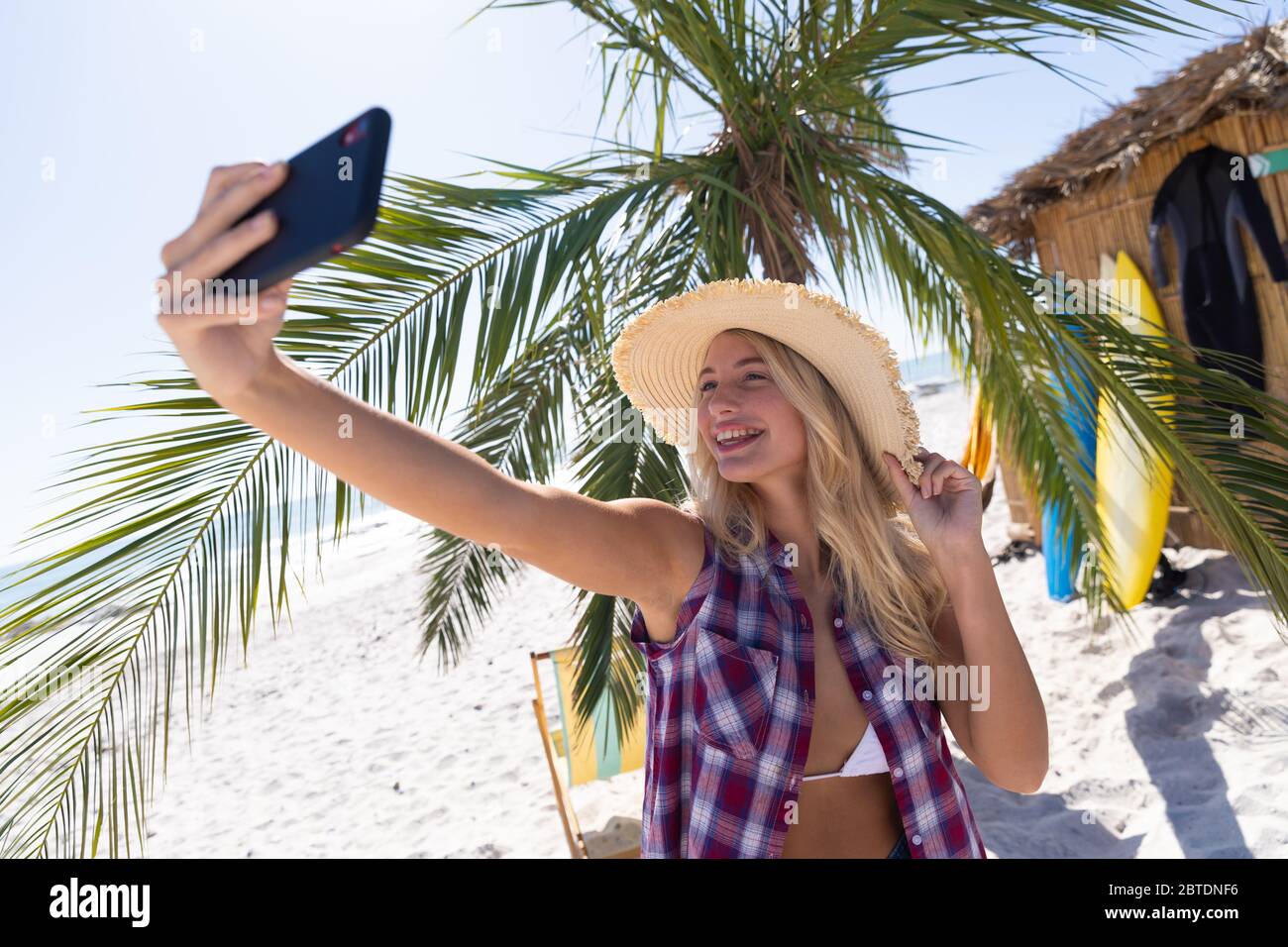 Femme caucasienne prenant un selfie à la plage Banque D'Images