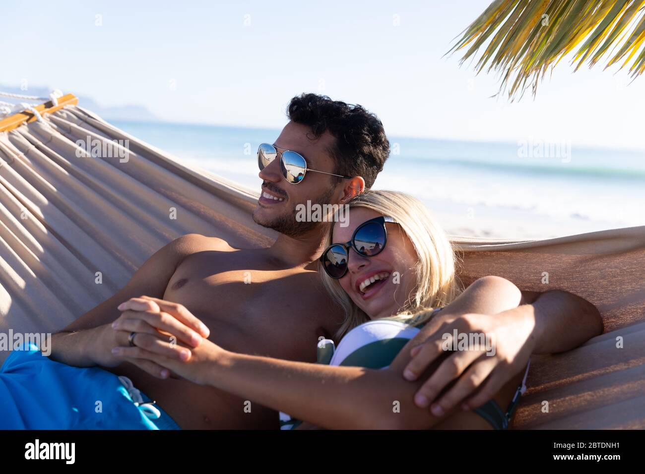 Couple caucasien allongé sur un hamac à la plage. Banque D'Images