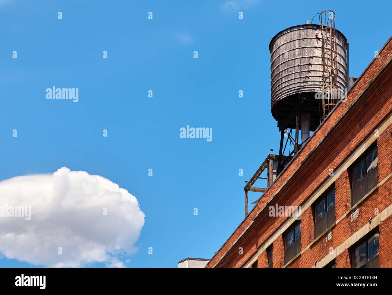 Réservoir d'eau sur le toit par temps ensoleillé, l'un des symboles de New York, USA. Banque D'Images