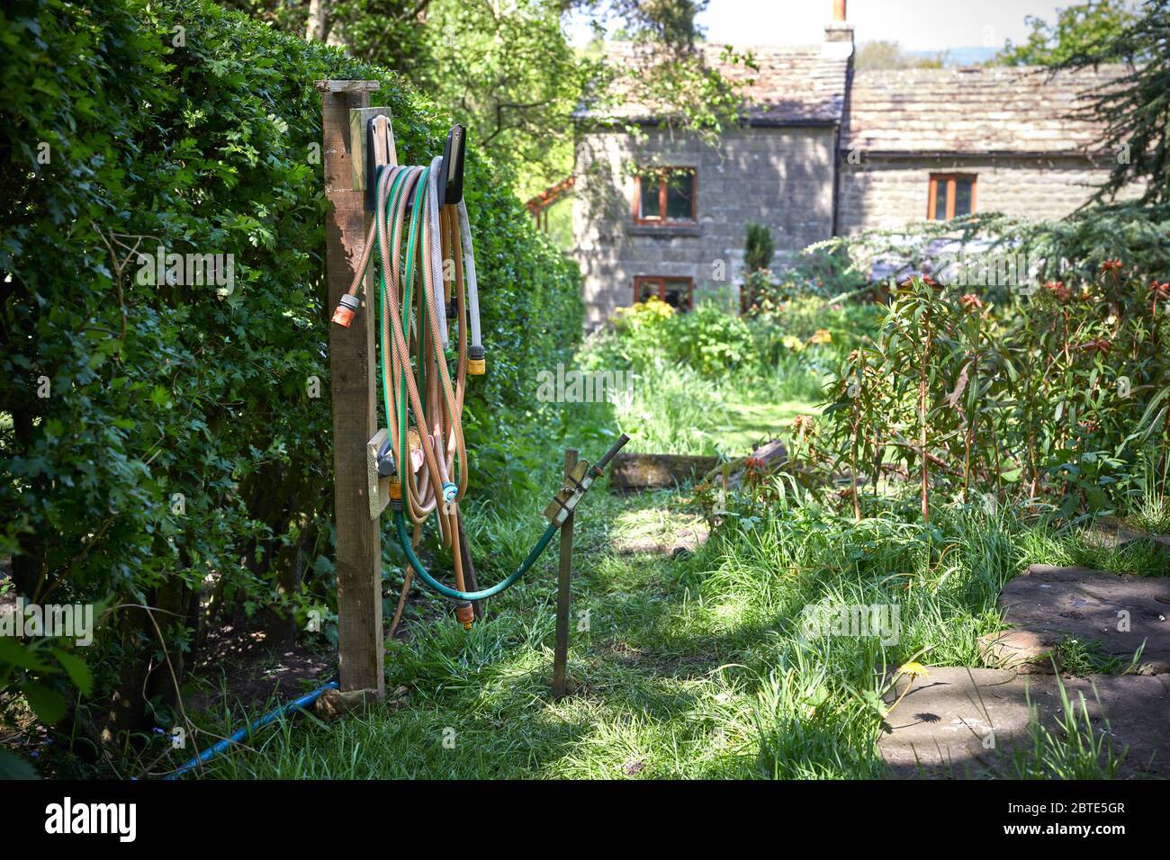 Pein Lane, Bewerley, Harrogate, North Yorkshire, Angleterre, Royaume-Uni. 20/05/20. Tuyau flexible enroulé soigneusement sur un seul crochet de rangement dans la petite exploitation amateur Banque D'Images