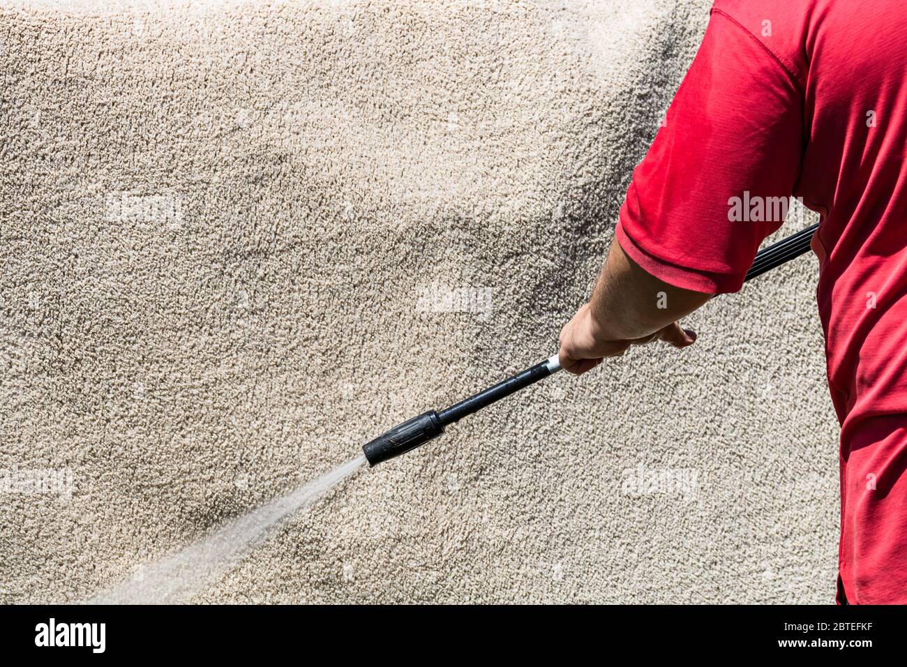 Gros plan sur le lavage des tapis avec un nettoyeur haute pression. Nettoyage de la moquette avec un pistolet pour le lavage de l'eau haute pression. Concept de nettoyage de maison. Banque D'Images