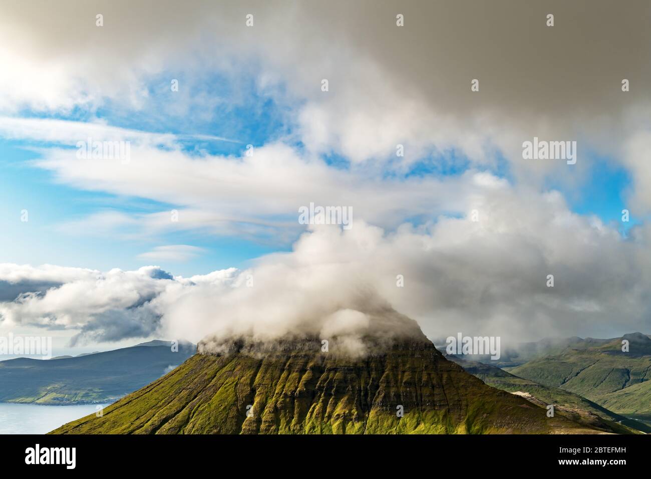 Foggy Mountain peaks et les nuages couvrant la mer et les montagnes. Panoramical view à partir de la célèbre place - Sornfelli sur Streymoy island, îles Féroé, Danemark. Photographie de paysage Banque D'Images
