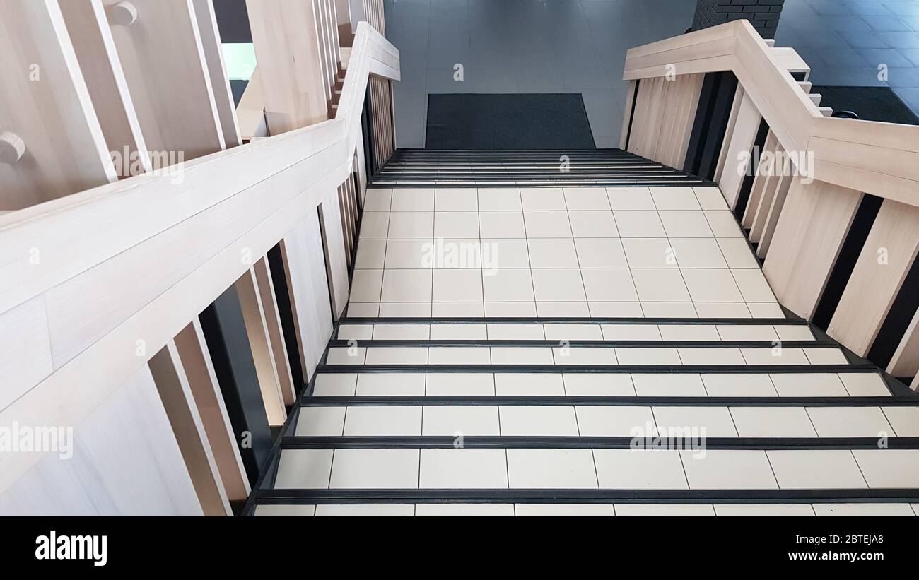 vue de dessus en bas des escaliers de carrelage et de bois clair à l'intérieur. Banque D'Images