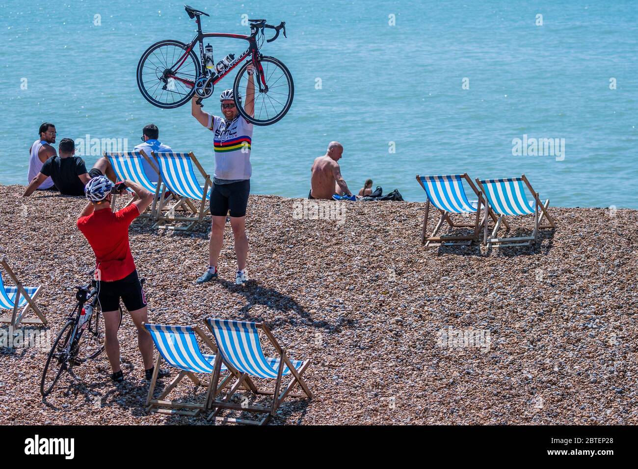 Brighton, Royaume-Uni. 25 mai 2020. Un cycliste célèbre sa réussite à vélo à Brighton - il est ensoleillé et les gens viennent à la plage et au bord de la mer à Brighton, pendant les vacances de la banque lundi. Il est occupé mais encore plentyu de place pour la distanciation sociale. Le « verrouillage » facilité se poursuit pour l'épidémie du coronavirus (Covid, 19). Crédit : Guy Bell/Alay Live News Banque D'Images