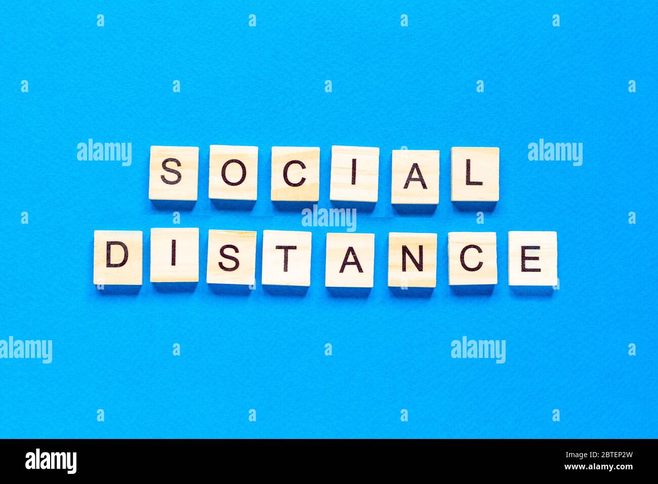 Distance sociale des mots. Inscription en bois sur fond bleu. Information signe de distance sociale de blocs sur fond bleu. Vue de dessus, plat l Banque D'Images