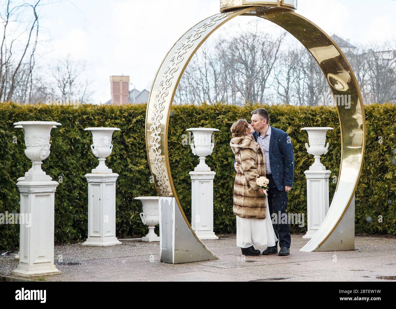 couple nouvellement kising dans le parc de la ville le début du printemps par jour neigeux Banque D'Images