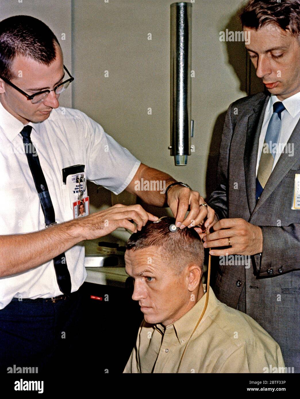 (2 décembre 1965) --- L'astronaute Frank Borman, Gemini-7, siège pilote commande attentivement comme deux électrodes sont attachées à sa tête. Les électrodes permettra aux médecins d'enregistrer l'activité électrique du cortex cérébral de l'astronaute durant les périodes de l'apesanteur. Les objectifs de cette expérience en vol sont à évaluer l'état de la vigilance, de la conscience, et la profondeur du sommeil. Banque D'Images