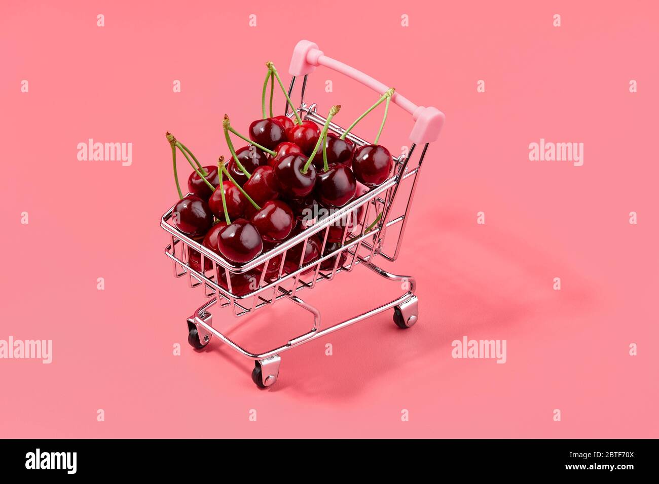 Cerises fraîches et juteuses dans un panier à roulettes, concept de marché aux fruits de saison Banque D'Images