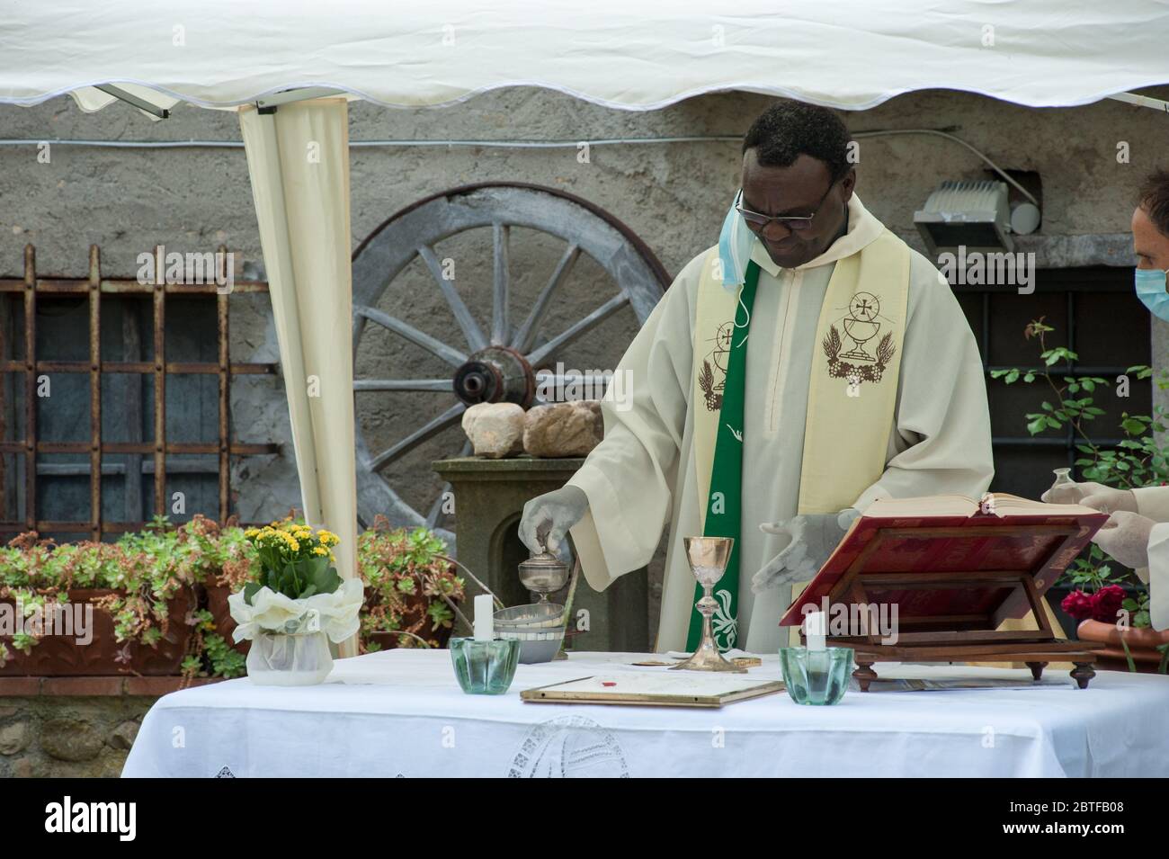 Italie - 2020, 24 mai : le prêtre africain célèbre la messe pendant le verrouillage du covid-19, portant des gants et des masques protecteurs. Banque D'Images