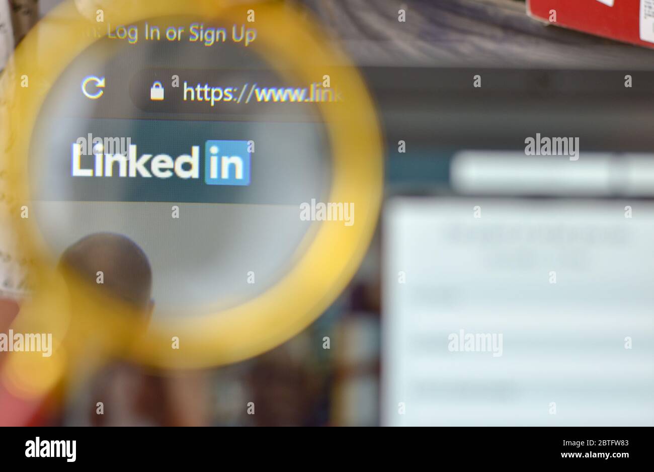 New York, États-Unis, 2020. Page d'inscription au site LinkedIn via une loupe. L'écran de l'ordinateur portable est hors foyer en arrière-plan. Concept de réseau social Banque D'Images