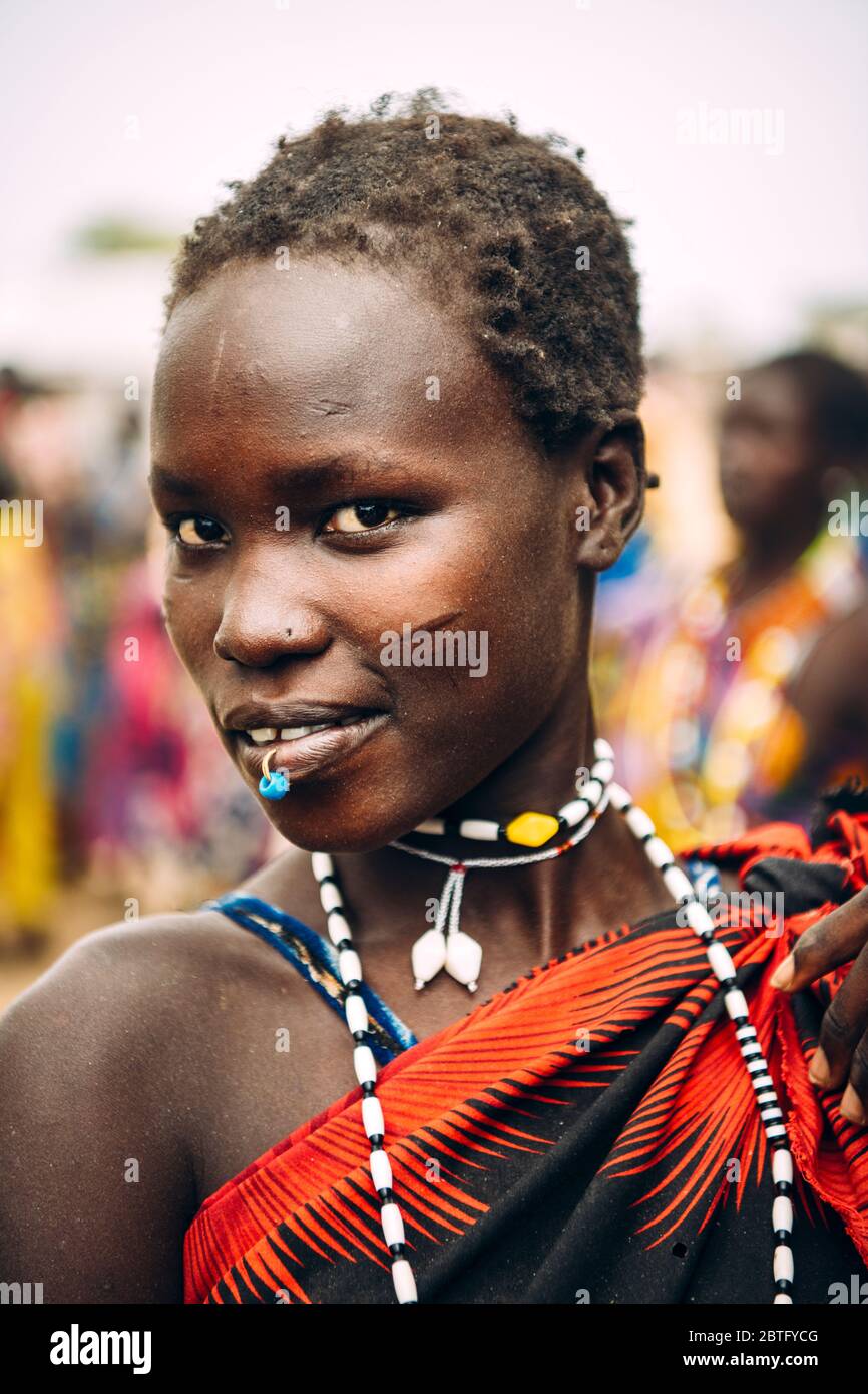 Tribu TOPOSA, SOUDAN DU SUD - 12 MARS 2020: Jeune femme avec piercing et cheveux courts souriant et regardant la caméra tout en vivant à Toposa Tribe Banque D'Images
