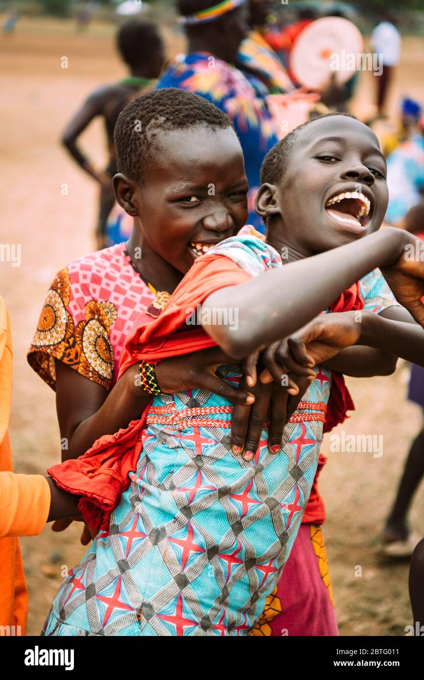 Tribu TOPOSA, SOUDAN DU SUD - 12 MARS 2020 : adolescent de la tribu Toposa souriant et embrassant un ami hurlant de derrière tout en s'amusant sur le village Banque D'Images