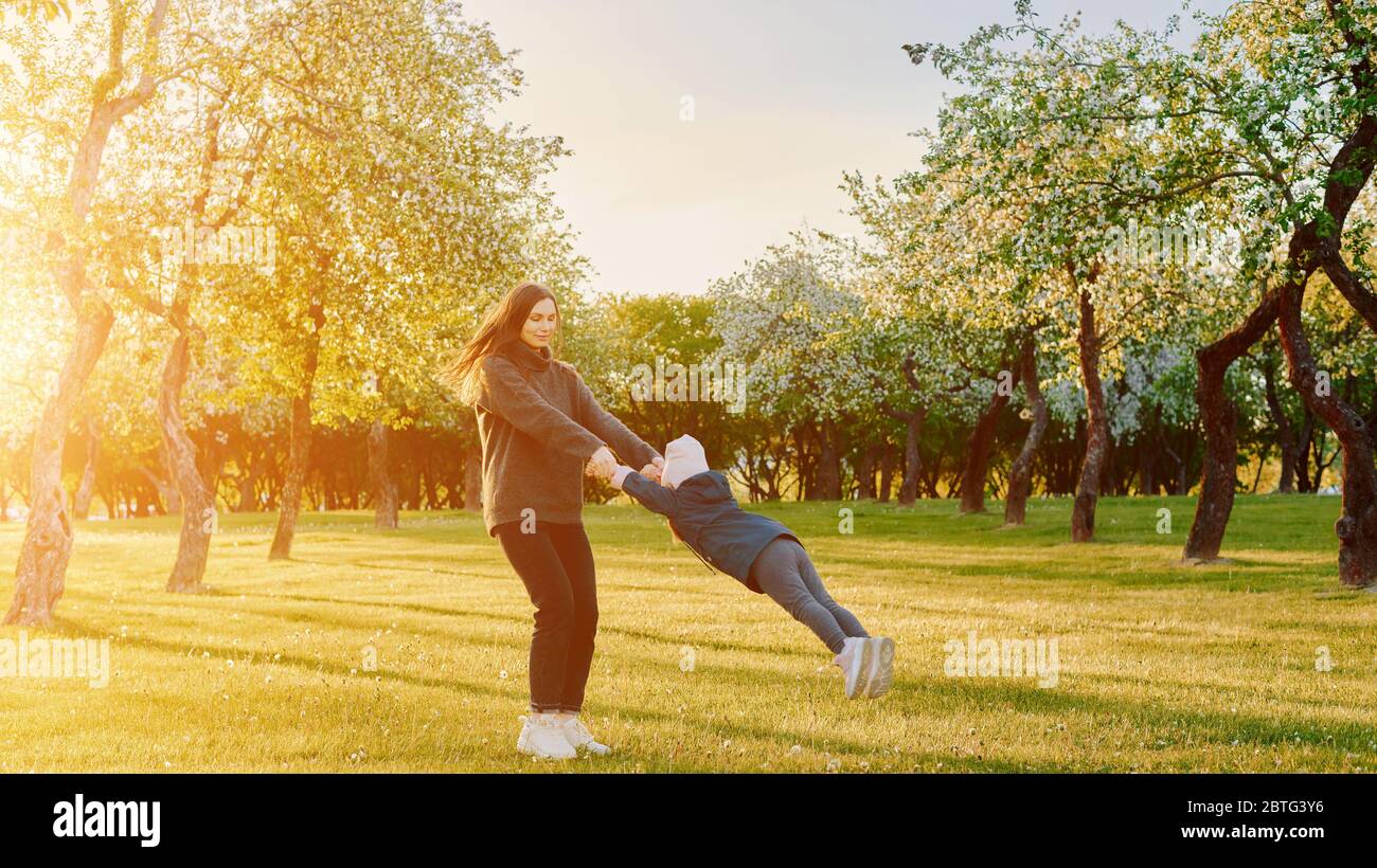 Mère avec enfants jouant dans un parc au coucher du soleil. Femme girls fille. Parent actif avec enfants Banque D'Images