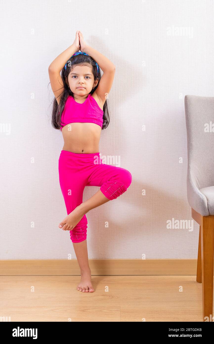 Petite fille mignonne faisant du yoga à la maison Banque D'Images