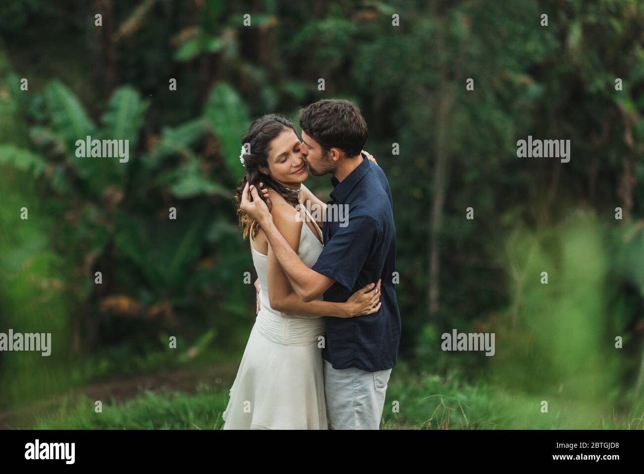 Jeune couple d'Amérique latine avec la vue étonnante de Ubud rizières en terrasse le matin. Heureux ensemble, de miel à Bali. Style de voyage. Banque D'Images