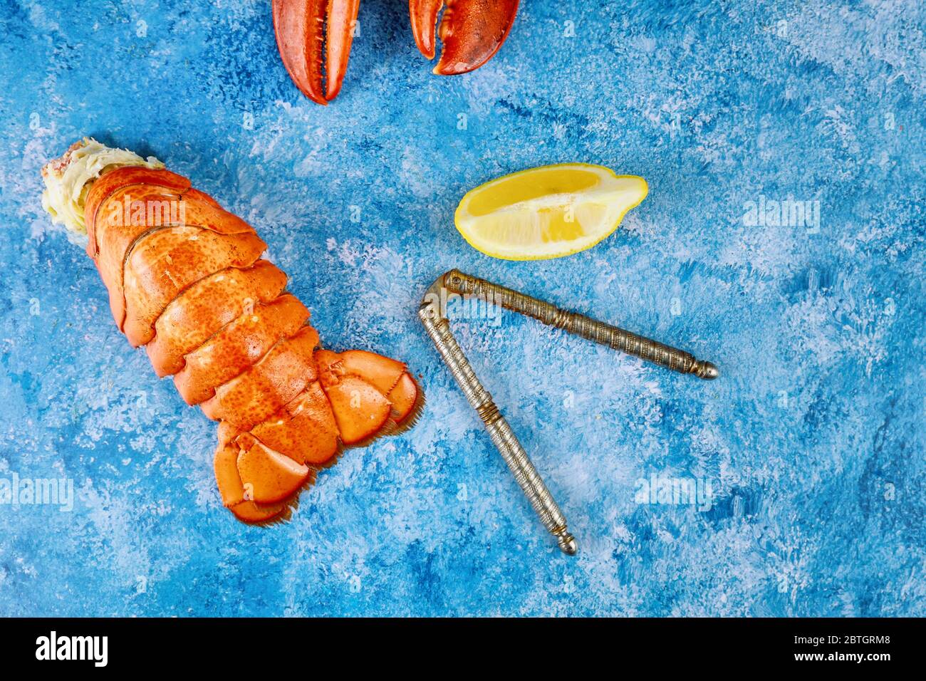 Homard rouge cuit savoureux avec citron sur fond bleu Banque D'Images