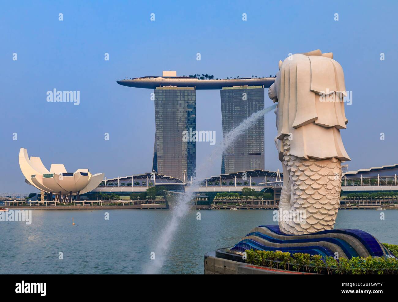 Singapour - 9 septembre 2019 : célèbre hôtel de luxe et casino en forme de surf Marina Bay Sands avec la célèbre fontaine Merlion en premier plan Banque D'Images