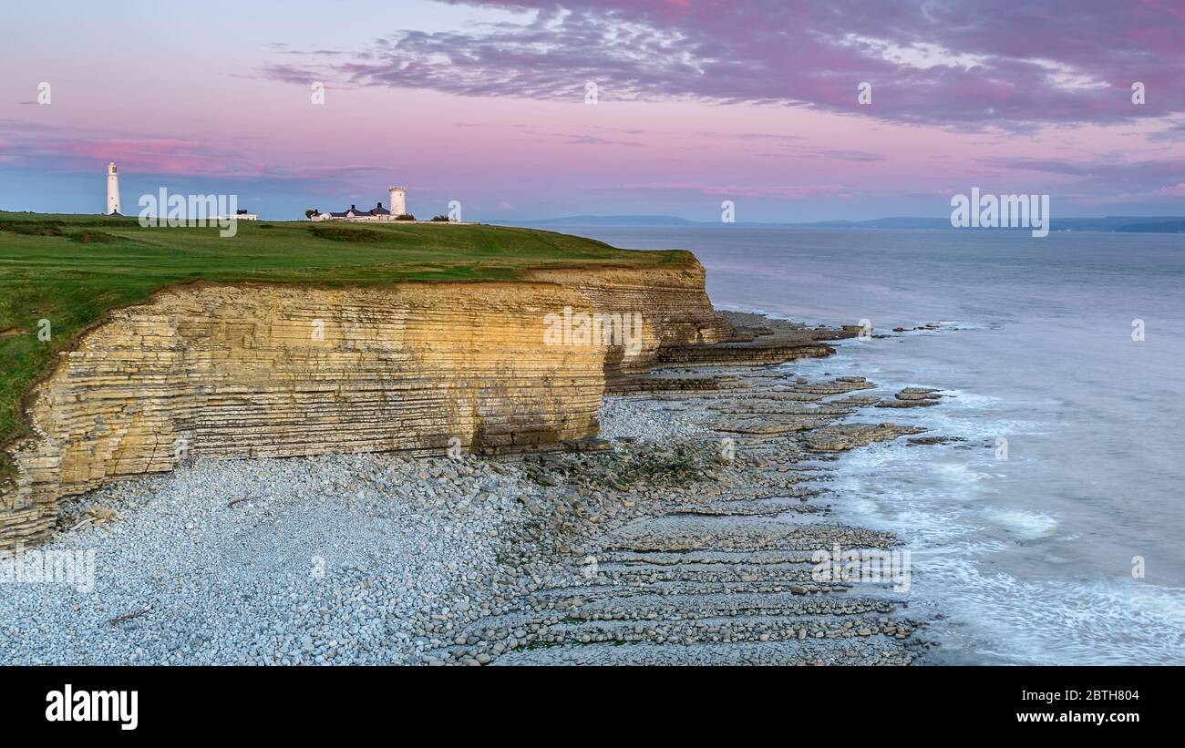 Phare de Nash point, sud du pays de Galles, au coucher du soleil. Le phare est situé au sommet de falaises abruptes, surplombant le canal de Bristol Banque D'Images