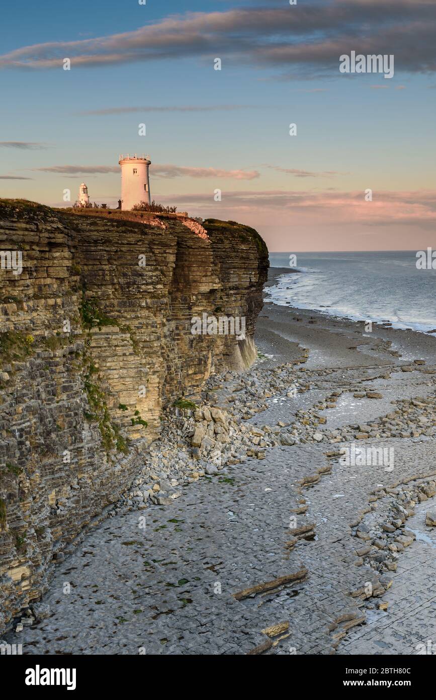 Phare de Nash point, sud du pays de Galles, au coucher du soleil. Le phare est situé au sommet de falaises abruptes, surplombant le canal de Bristol Banque D'Images