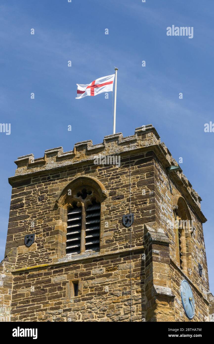 Drapeau de St George volant de la tour de l'église de St Columba, Collingtree, Northampton, Royaume-Uni Banque D'Images