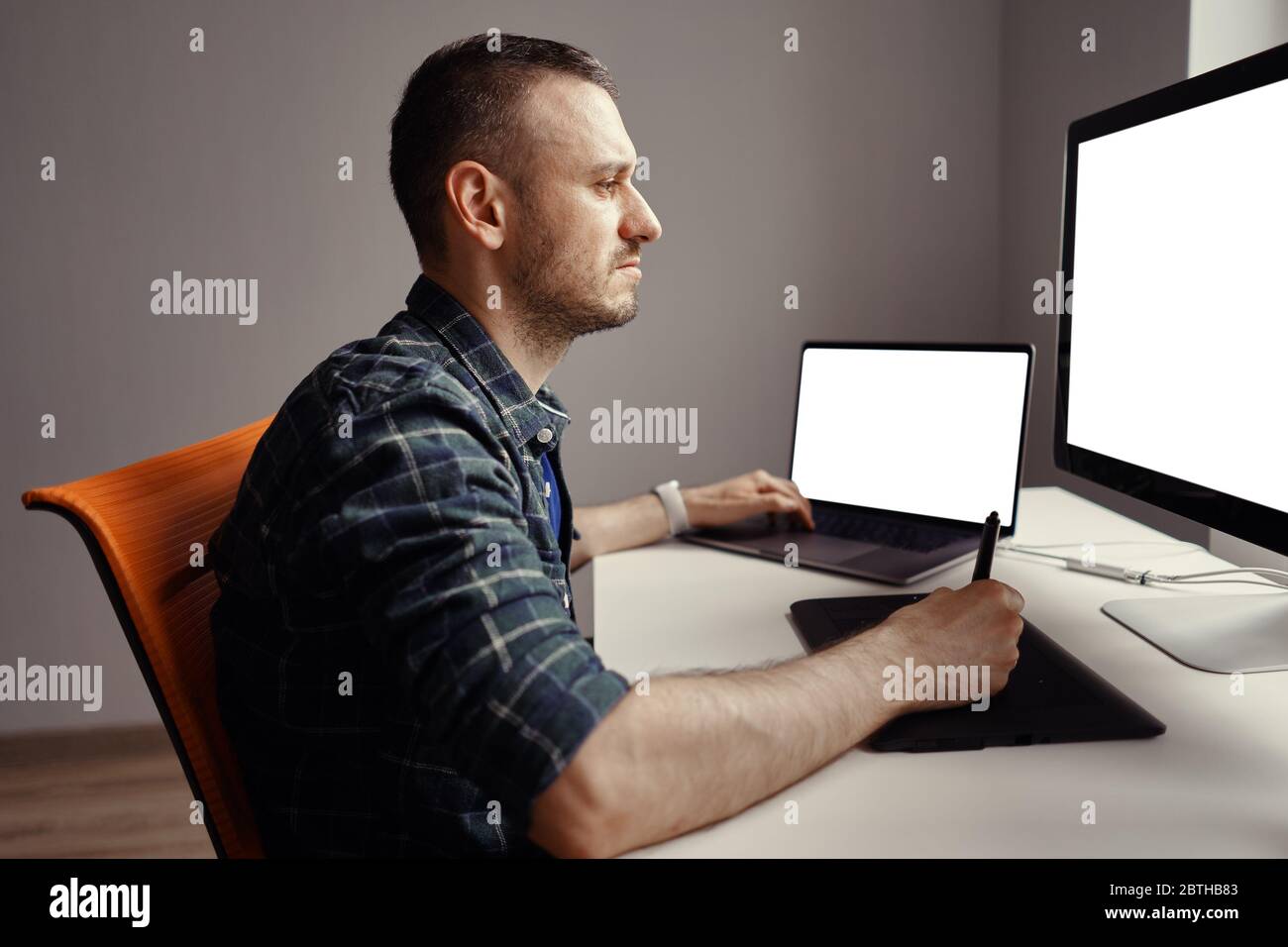 Graphiste travaillant avec un écran interactif à stylet, une tablette de dessin numérique et un stylet sur un ordinateur avec un moniteur vierge Banque D'Images