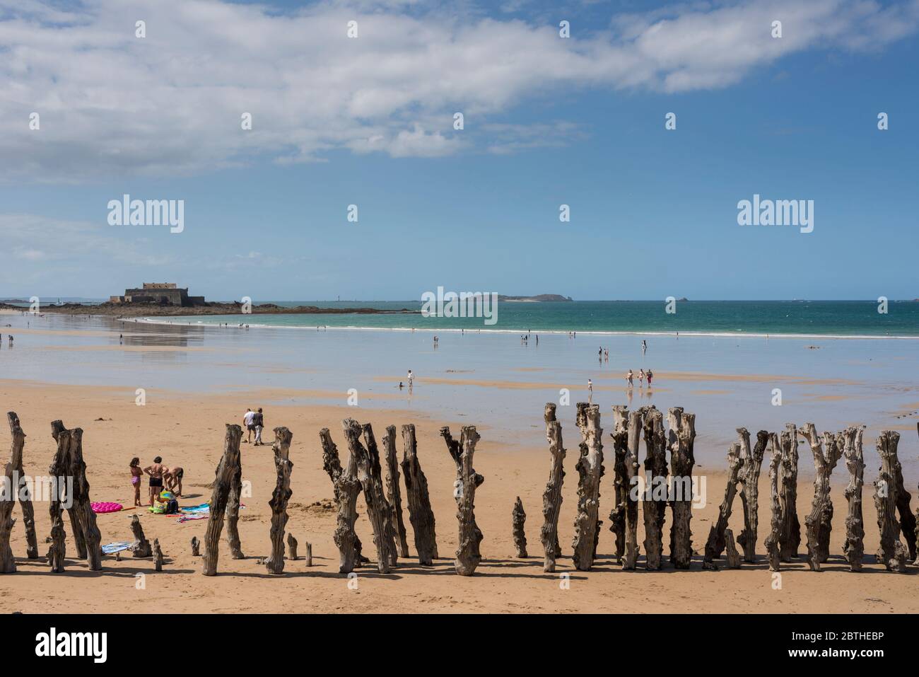 Les gens sur une plage de sable et vue sur mer avec Fort National dans l'arrière-plan, Bretagne, France Banque D'Images