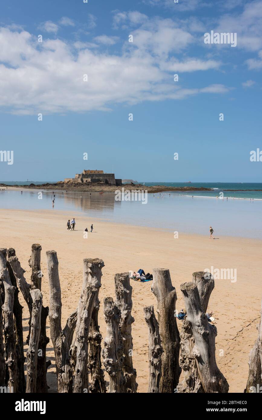 Les gens sur une plage de sable et vue sur mer avec Fort National dans l'arrière-plan, Bretagne, France Banque D'Images