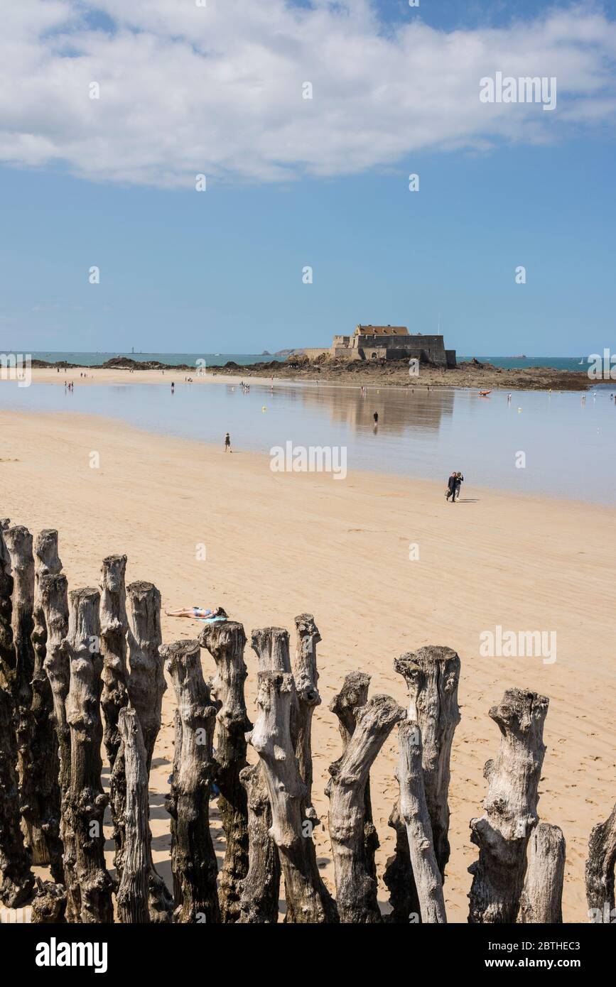 Les gens sur une plage de sable et vue sur mer avec Fort National dans l'arrière-plan, Bretagne, France Banque D'Images