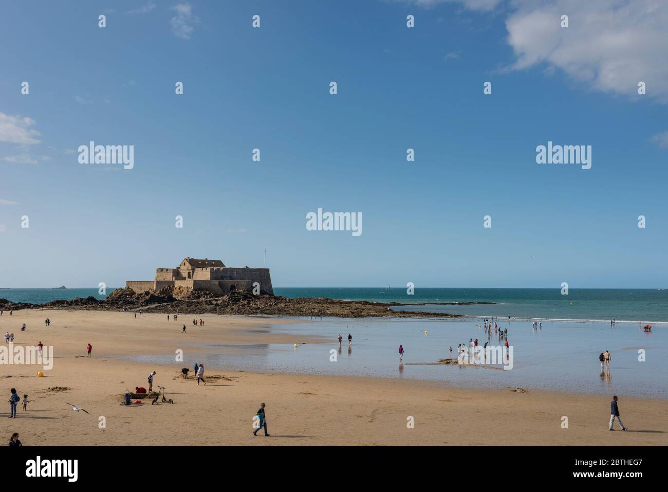 Les gens sur une plage de sable et vue sur mer avec Fort National dans l'arrière-plan, Bretagne, France Banque D'Images