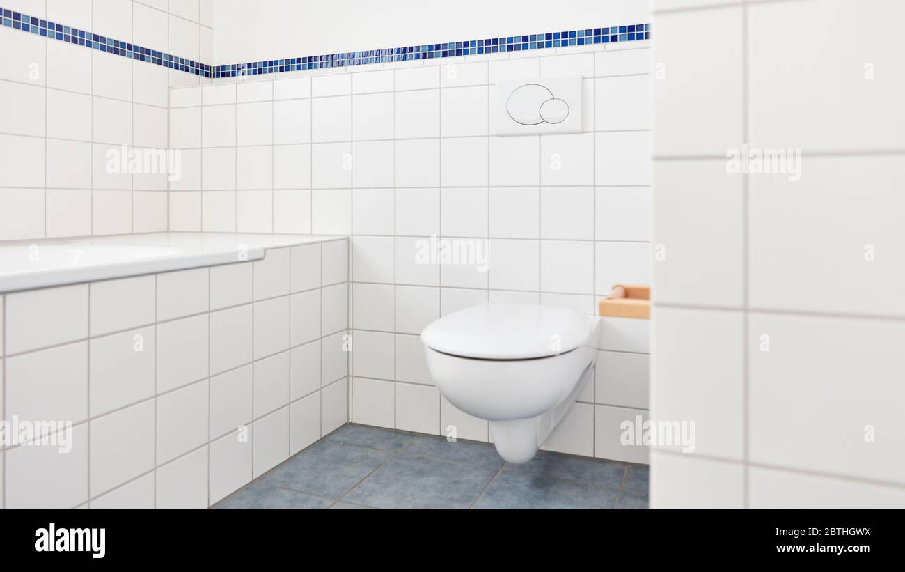 Toilettes modernes et propres dans la salle de bains à côté de la baignoire avec carreaux blancs Banque D'Images