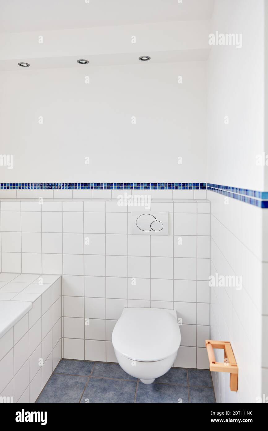 Toilettes propres dans la salle de bains avec carrelage blanc à la maison à côté de la baignoire Banque D'Images