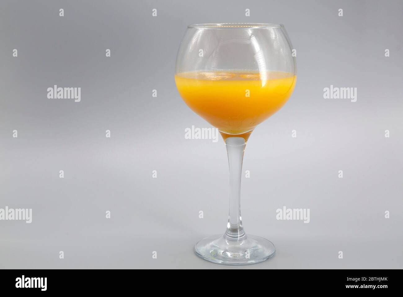 Une slammer d'Alabama servie dans un verre à ballons. Le cocktail comprend du confort du Sud, du Sloe Gin, de l'Amaretto et du jus d'orange. Banque D'Images
