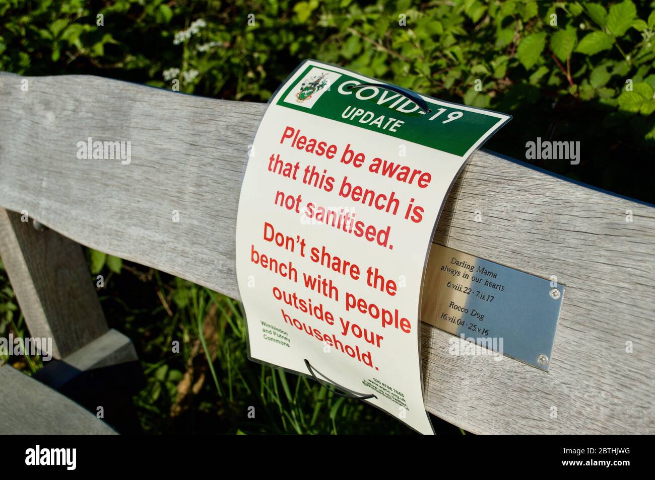 Un panneau d'avertissement Covid-19 sur un banc à Wimbledon Common, Londres, Royaume-Uni Banque D'Images