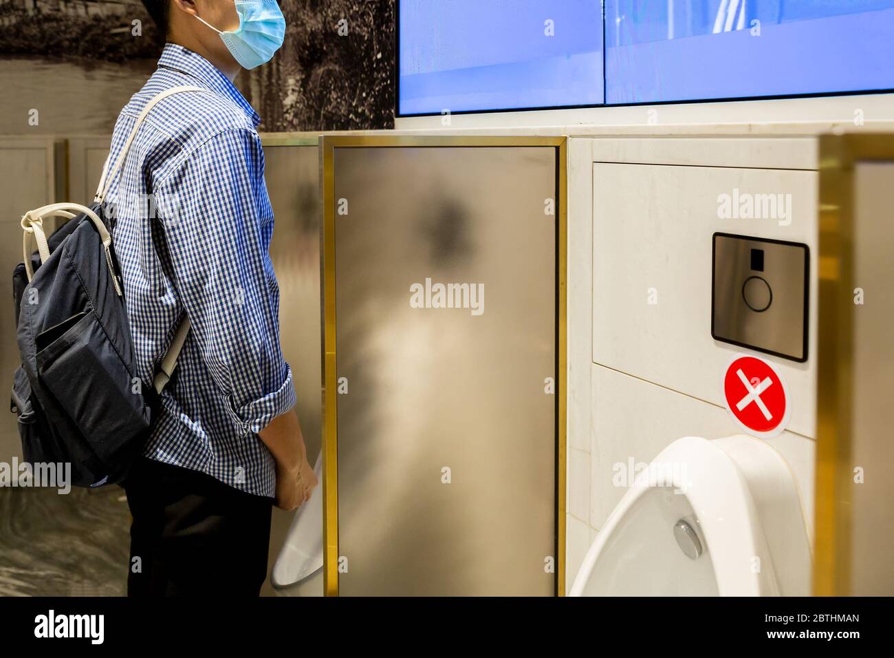 Hommes pour la vie après COVID-19 dans les toilettes publiques. Nouvelle norme normale ou nouvelle norme règles de distanciation sociale en pratique. Banque D'Images