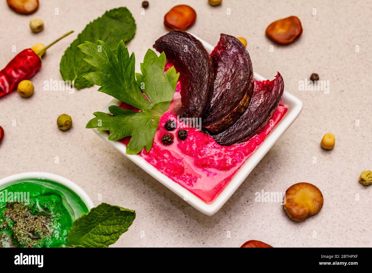 Hummus, nourriture végétalienne (végétarienne) saine. Trois types variés : classique, menthe et betterave. Haricots secs édamame, morceaux de pain pita, épices. Béton de pierre Banque D'Images