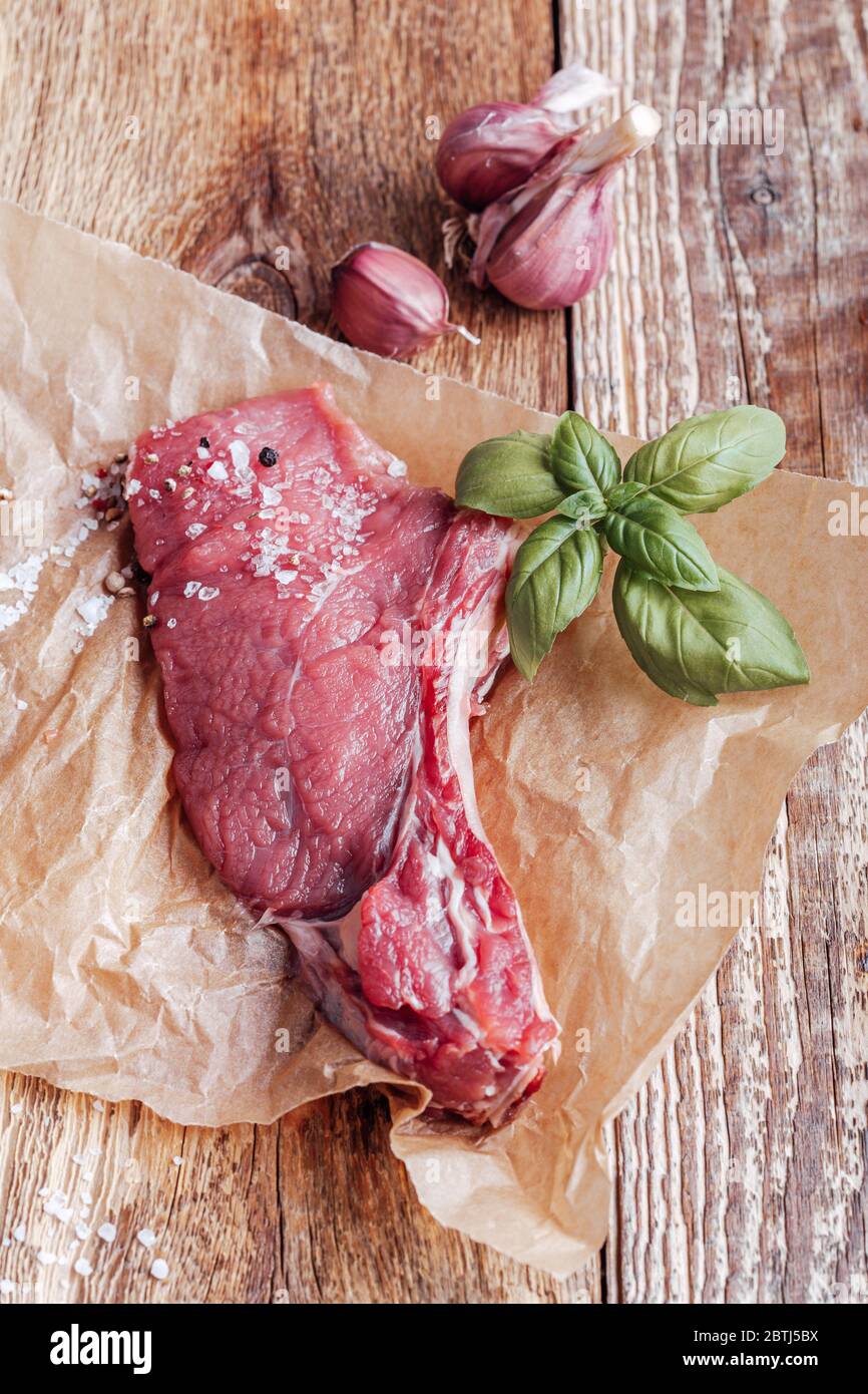 Steak de viande de bœuf biologique cru avec herbes et épices prêtes à cuire Banque D'Images