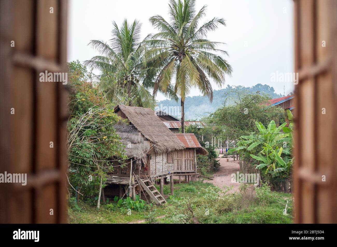 Vue par une fenêtre sur les autres maisons dans un petit village près du Mékong, du nord du Laos, de l'Asie du Sud-est Banque D'Images