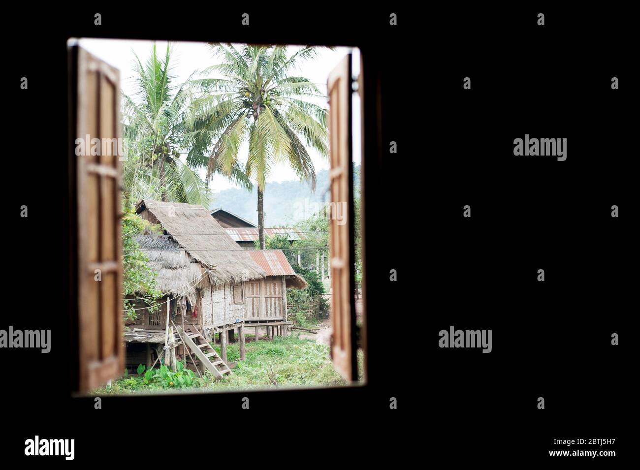 Vue par une fenêtre sur les autres maisons dans un petit village près du Mékong, du nord du Laos, de l'Asie du Sud-est Banque D'Images