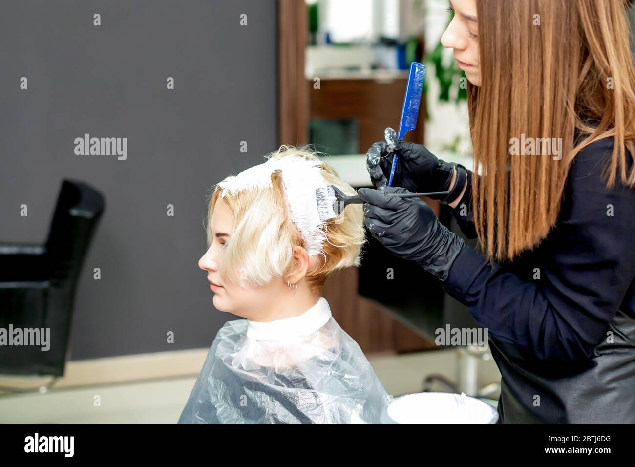 Coiffeur est teination cheveux de femme en couleur blanche à l'atelier de  coiffure Photo Stock - Alamy