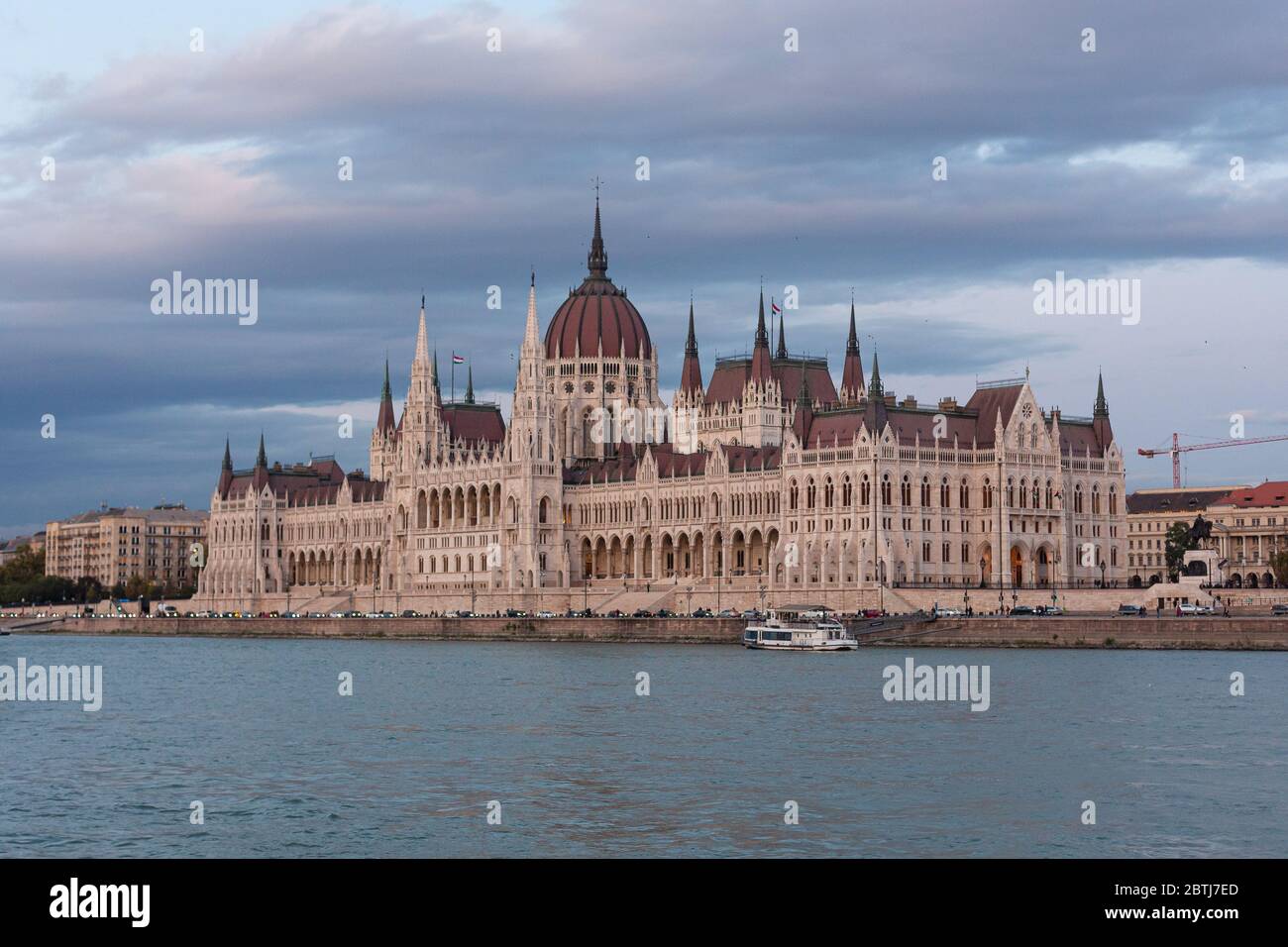 Le Parlement de Budapest s'est illuminé au coucher du soleil, vu d'une promenade en bateau sur le Danube Banque D'Images