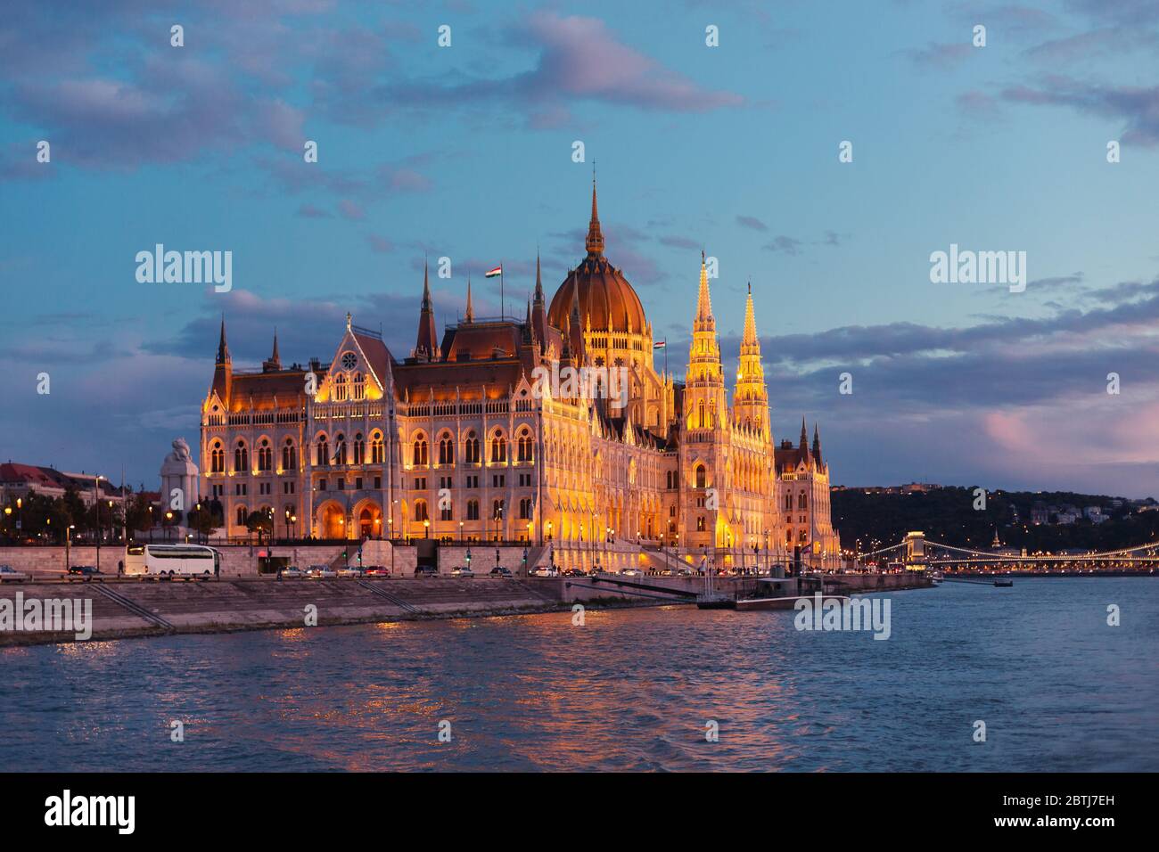 Le Parlement de Budapest s'est illuminé au coucher du soleil, vu d'une promenade en bateau sur le Danube Banque D'Images