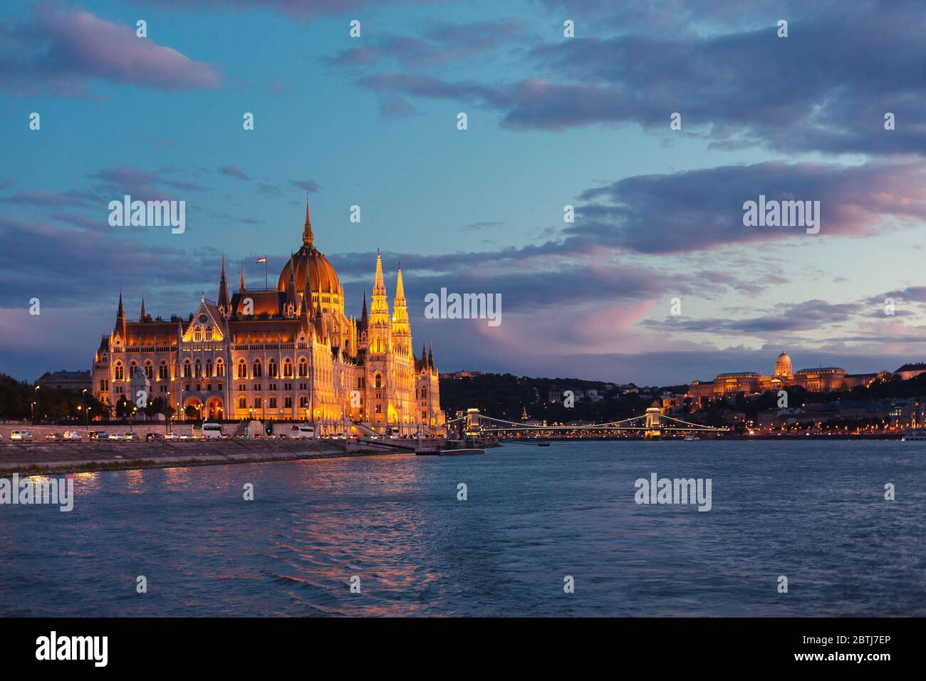 Le Parlement de Budapest s'est illuminé au coucher du soleil, vu d'une promenade en bateau sur le Danube Banque D'Images