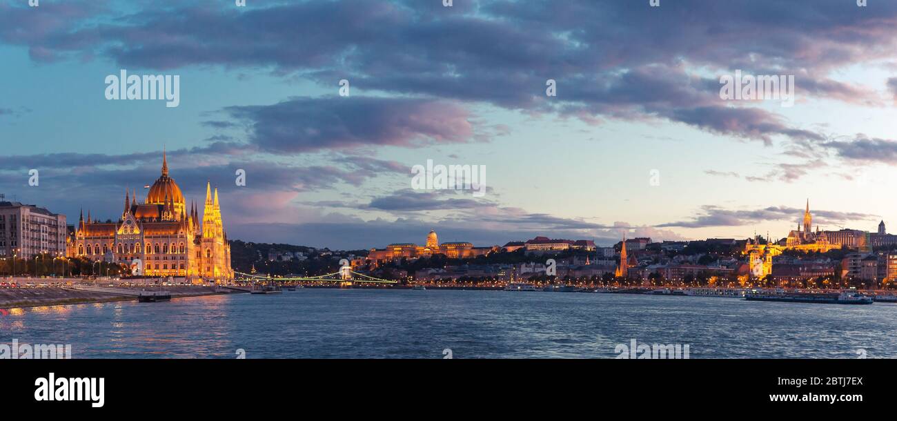 Le Parlement de Budapest s'est illuminé au coucher du soleil, vu d'une promenade en bateau sur le Danube Banque D'Images