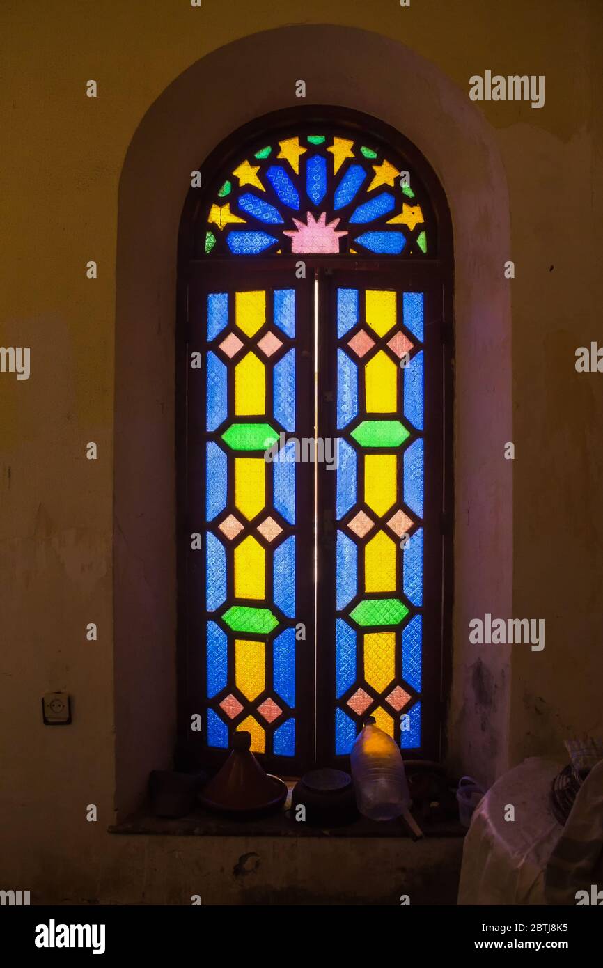 Partie bien conservée d'un complexe abandonné. Intérieur d'une chambre avec une fenêtre avec virage coloré et cadre en bois. Dar Caïd Hadji (utilisé aussi Hajji Banque D'Images